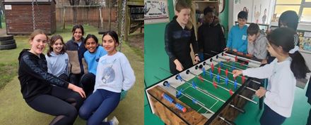 Pupils playing table football and sitting in a group