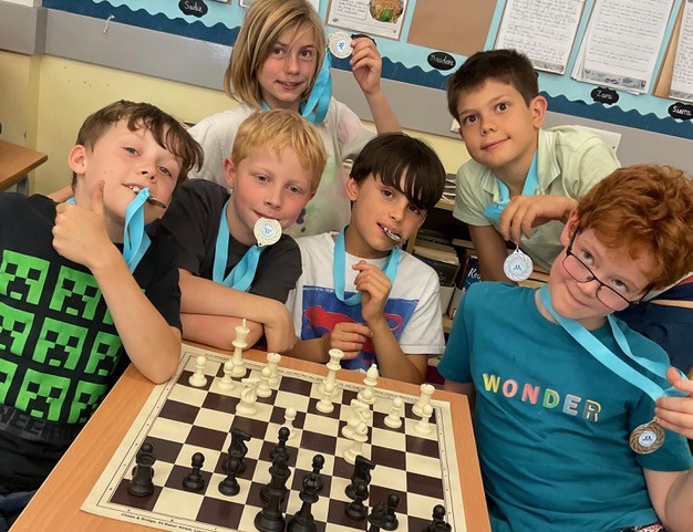 U9 - Y4 Children playing chess with medals
